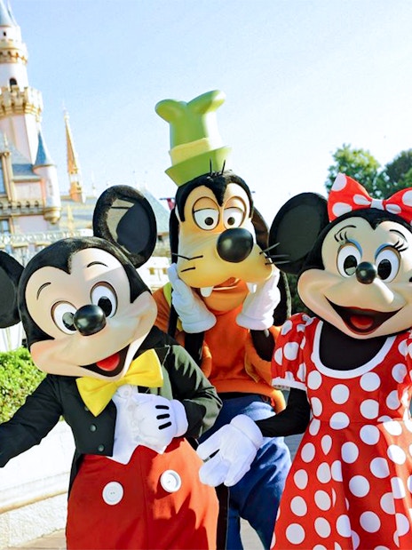 Mickey, Goofy, and Minnie in front of Disneyland Castle, California.
