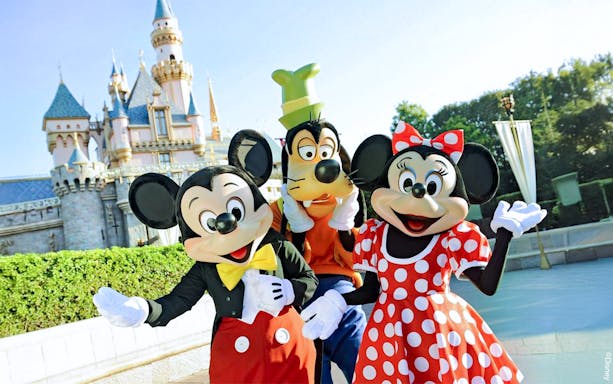 Mickey, Goofy, and Minnie in front of Disneyland Castle, California.