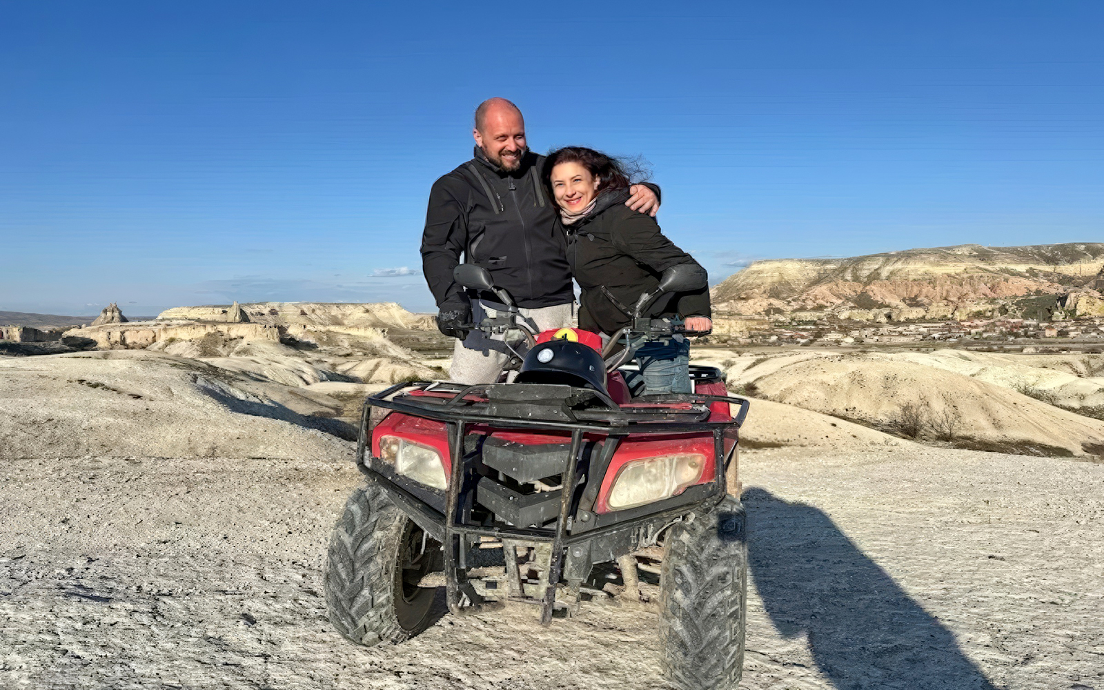 Guests on ATV tour in Cappadocia with rocky landscape in background.