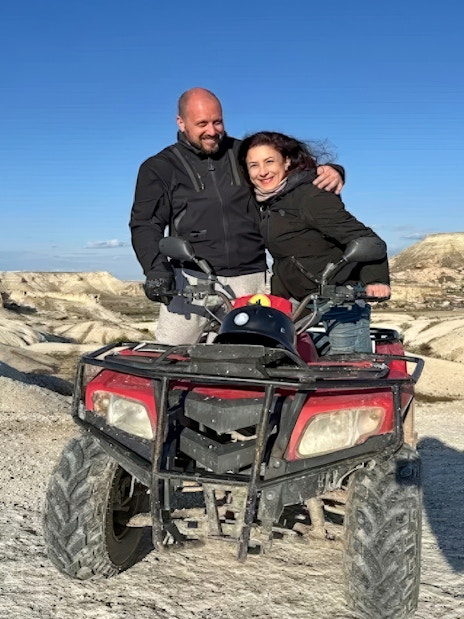 Guests on ATV tour in Cappadocia with rocky landscape in background.