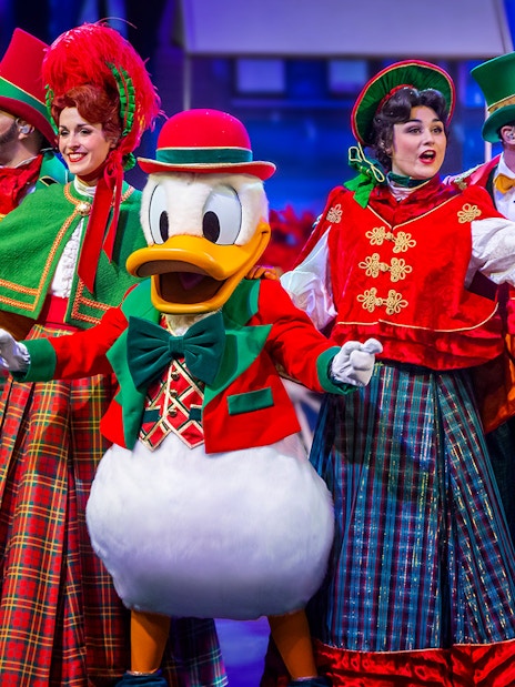 Disney characters performing in a festive musical show at Disneyland Paris.