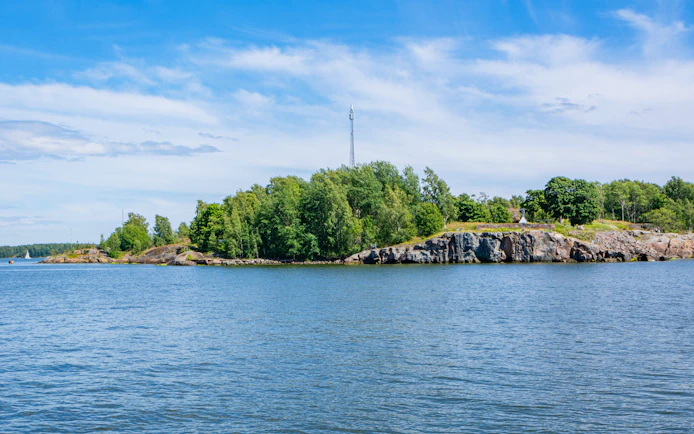 Rocky shore of Vallisaari island with trees and Gulf of Finland, Helsinki.