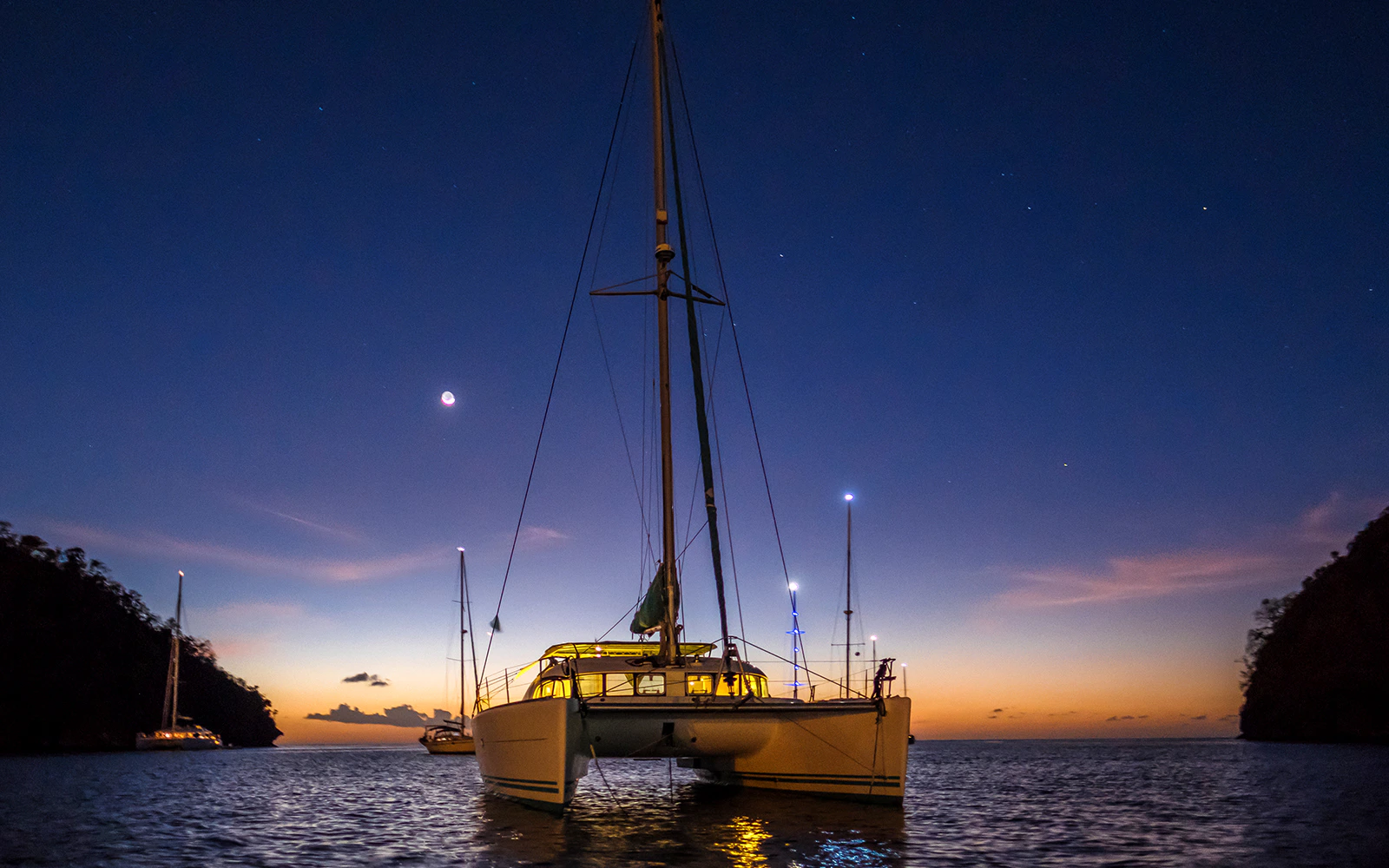 Catamaran sailing at sunset during a 2-hour night cruise in Lisbon.