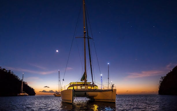 Catamaran sailing at sunset during a 2-hour night cruise in Lisbon.