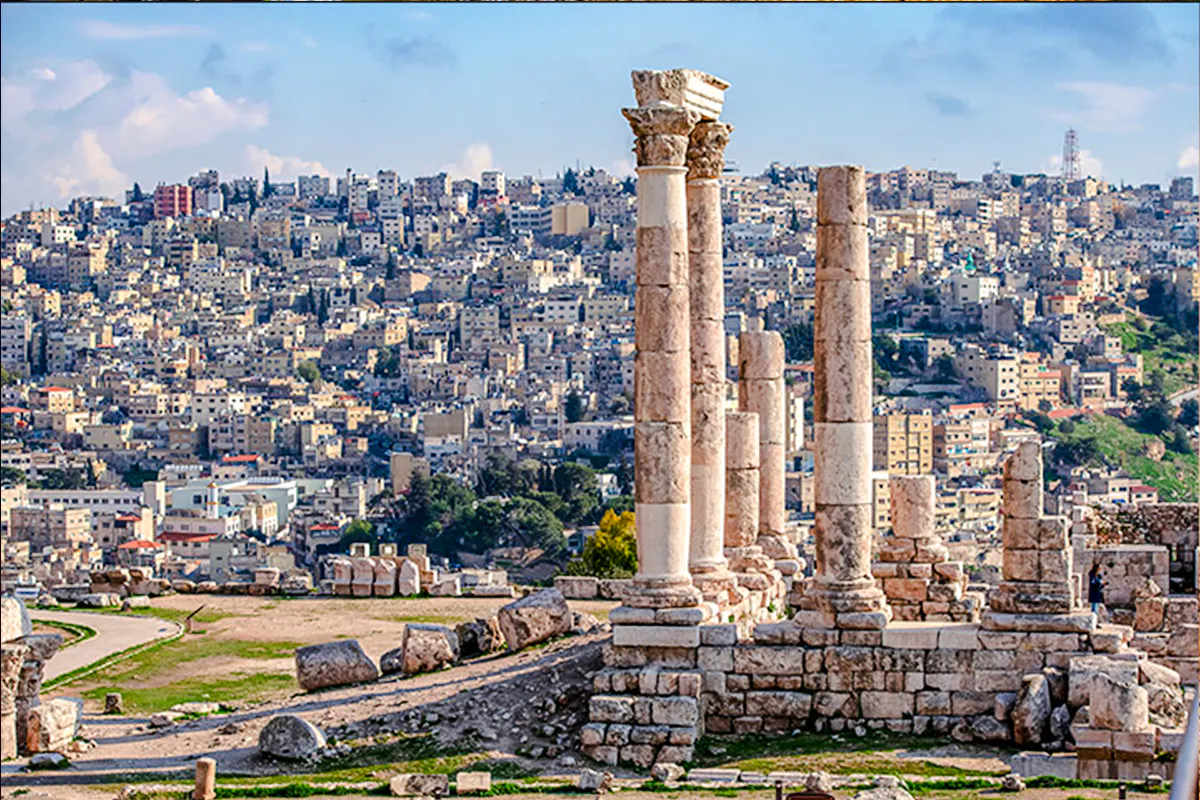 Roman columns at Amman Citadel with cityscape in the background, Amman City Sightseeing Tour.