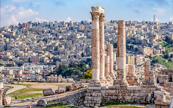 Roman columns at Amman Citadel with cityscape in the background, Amman City Sightseeing Tour.