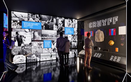 Visitors viewing exhibits at Camp Nou Barca Museum featuring Johan Cruyff memorabilia.