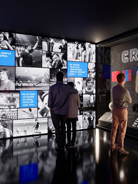 Visitors viewing exhibits at Camp Nou Barca Museum featuring Johan Cruyff memorabilia.