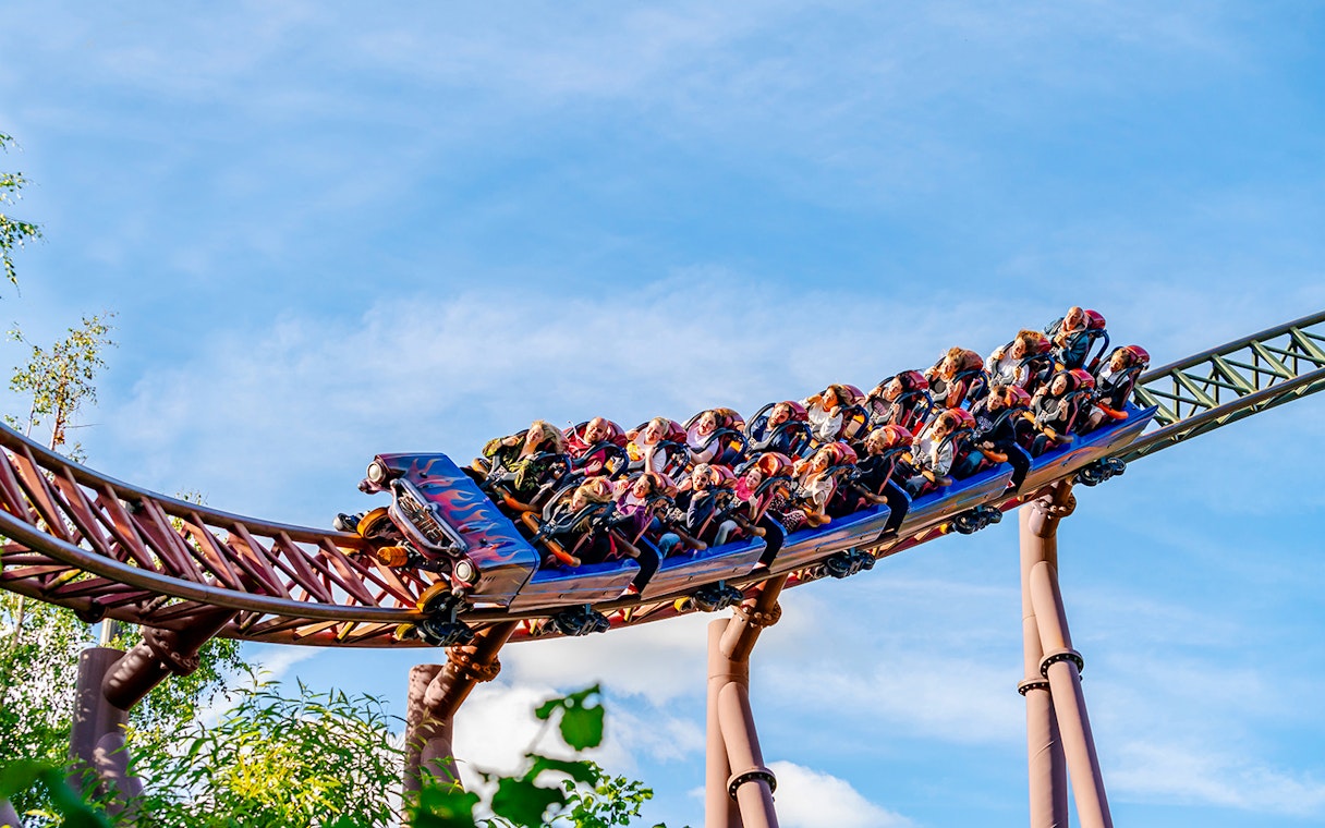 Riders on the Rita rollercoaster at Alton Towers, UK, speeding on a curved track.