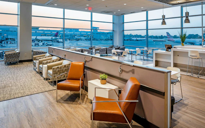 Aspire Lounge seating area with airport runway view at San Diego International Airport.