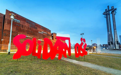 European Solidarity Centre entrance with red solidarity sign and monument in Gdańsk.