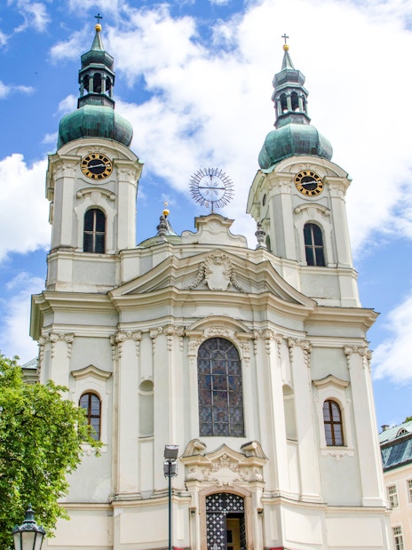 Church of Saint Mary Magdalene with twin towers in Karlovy Vary under a blue sky.