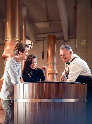 Heineken Experience guide demonstrating beer pouring in Amsterdam.