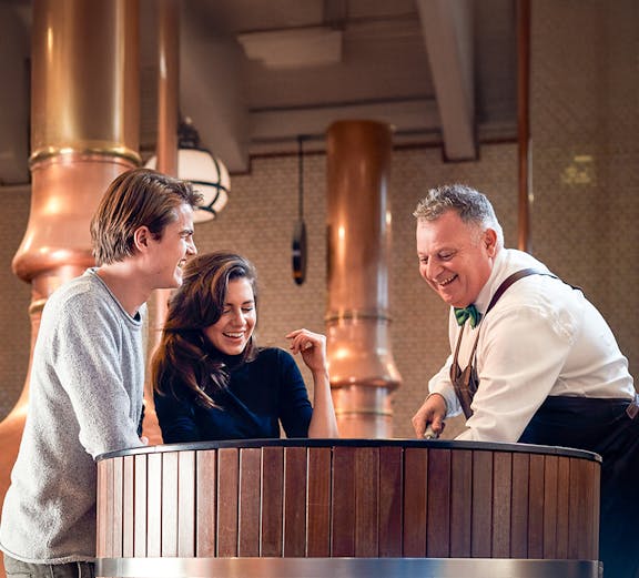 Heineken Experience guide demonstrating beer pouring in Amsterdam.