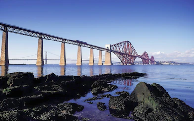 Forth Bridge over water near Edinburgh, part of Whisky & Waterfalls Day Tour.