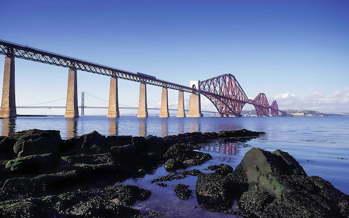 Forth Bridge over water near Edinburgh, part of Whisky & Waterfalls Day Tour.