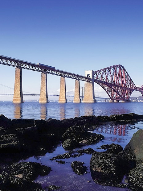 Forth Bridge over water near Edinburgh, part of Whisky & Waterfalls Day Tour.