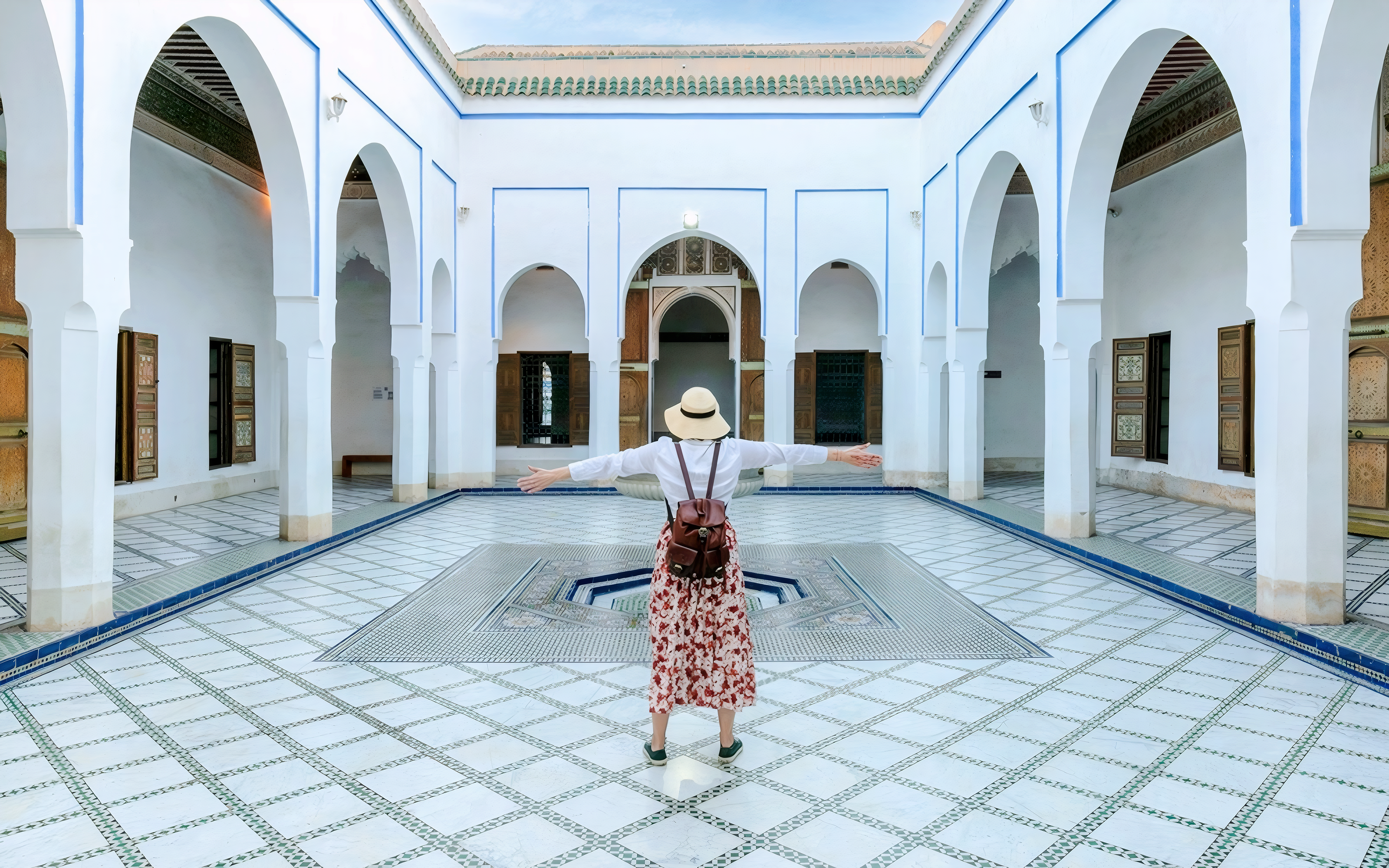 Person standing in courtyard of Bahia Palace, Marrakech, Morocco.