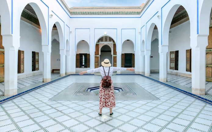 Person standing in courtyard of Bahia Palace, Marrakech, Morocco.
