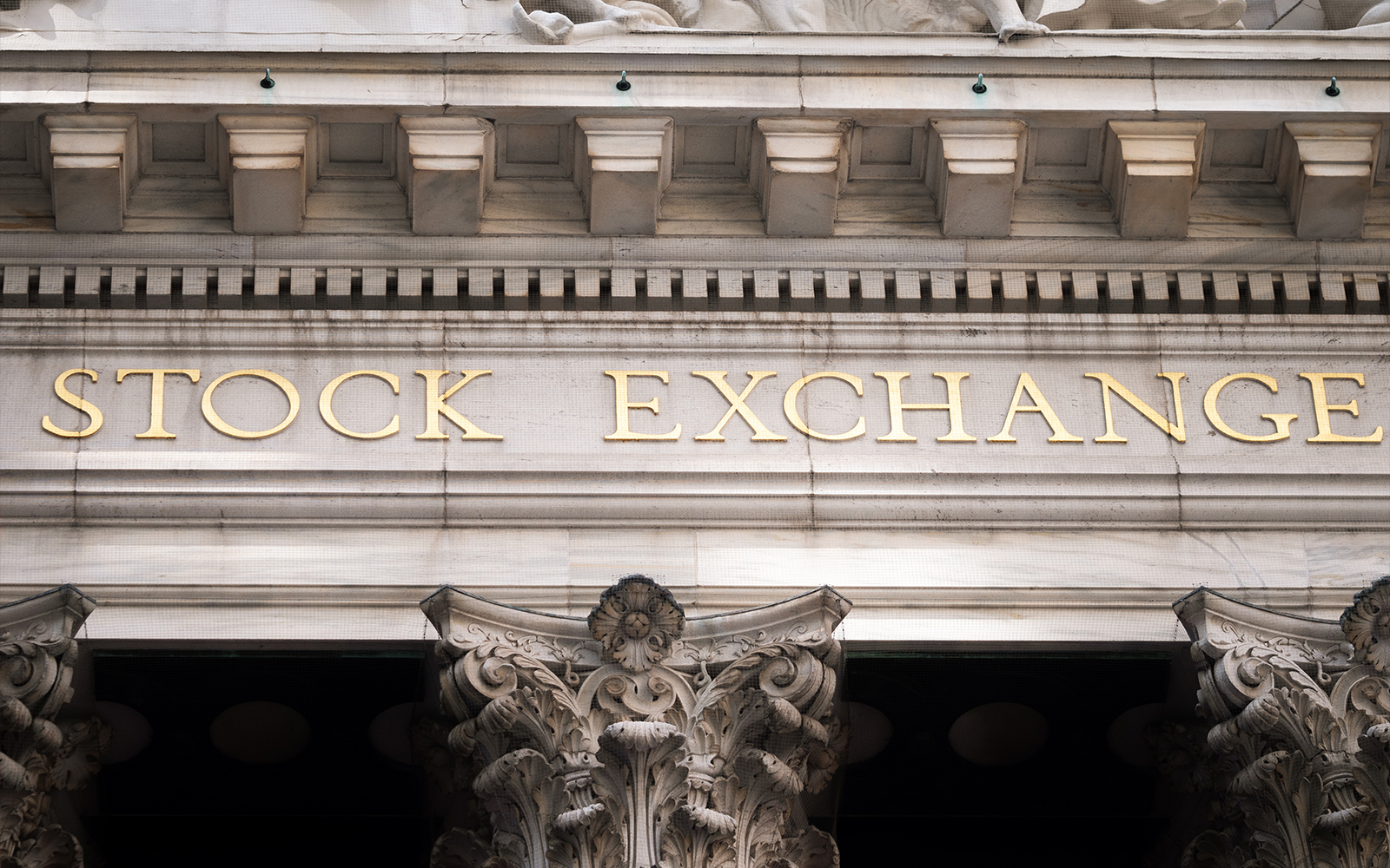 New York Stock Exchange facade on Wall Street, featuring ornate columns.