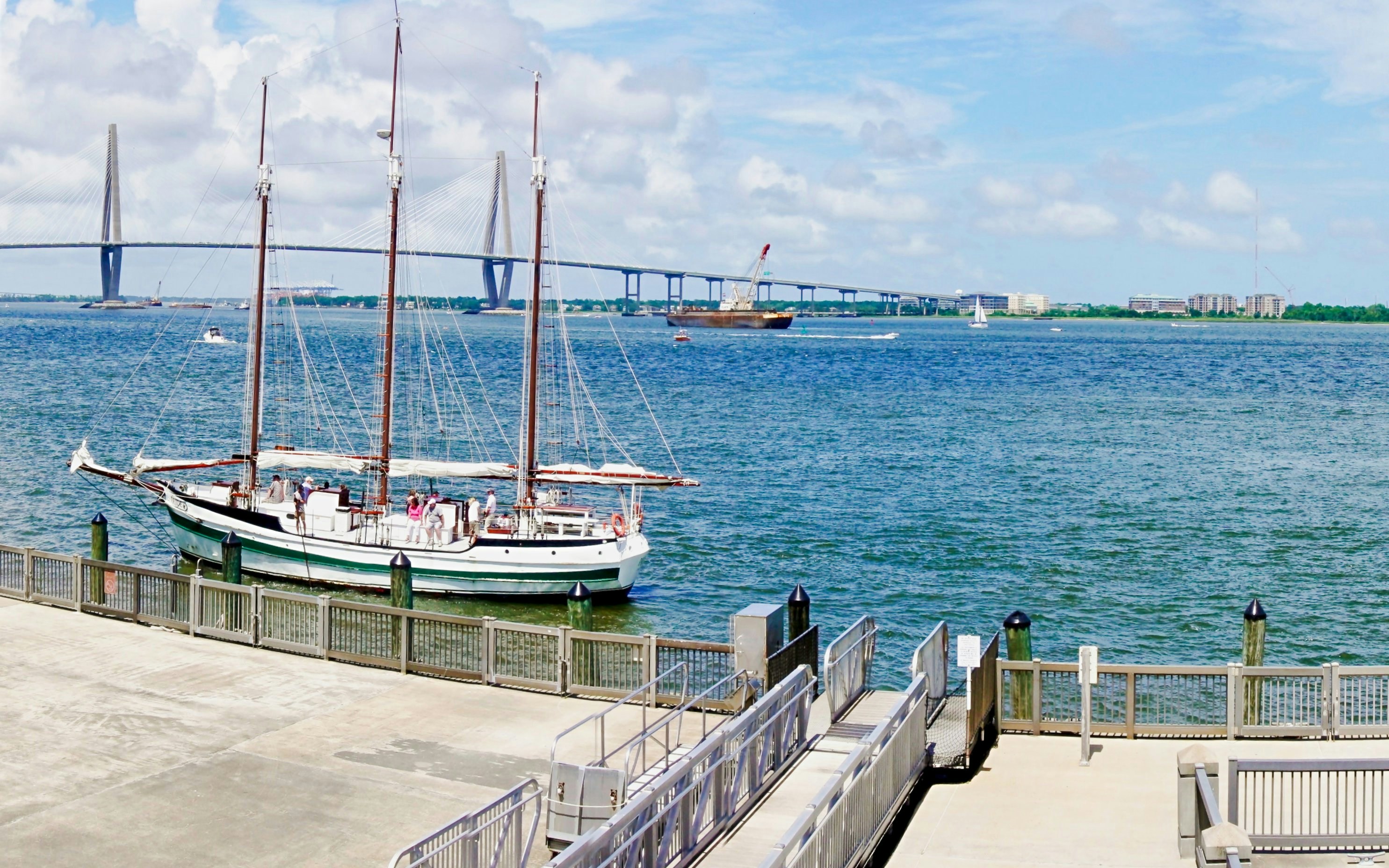 Charleston harbor view with sailboat and Arthur Ravenel Jr Bridge in the background.