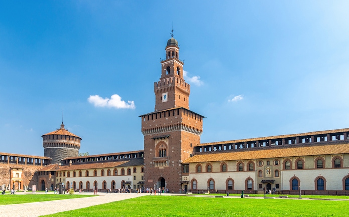 Sforza Castle courtyard in Milan with tourists exploring historic architecture.