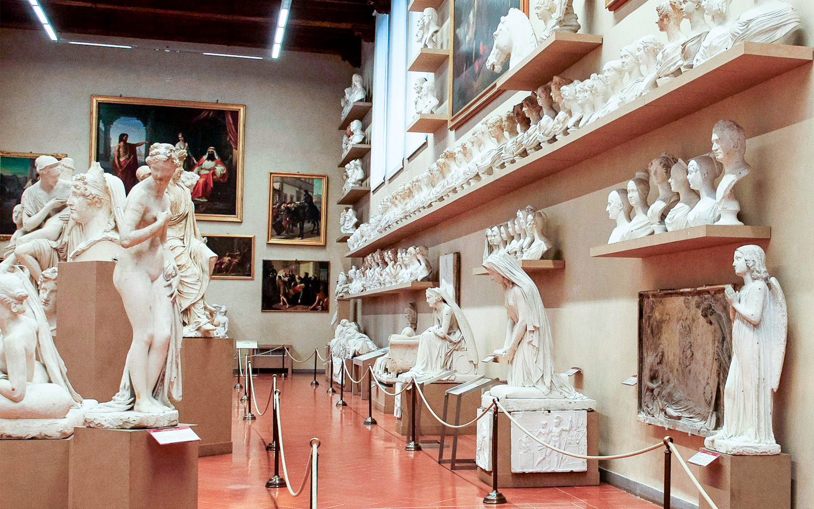 Sculptures and busts displayed in a gallery room at the Accademia Gallery, Florence.