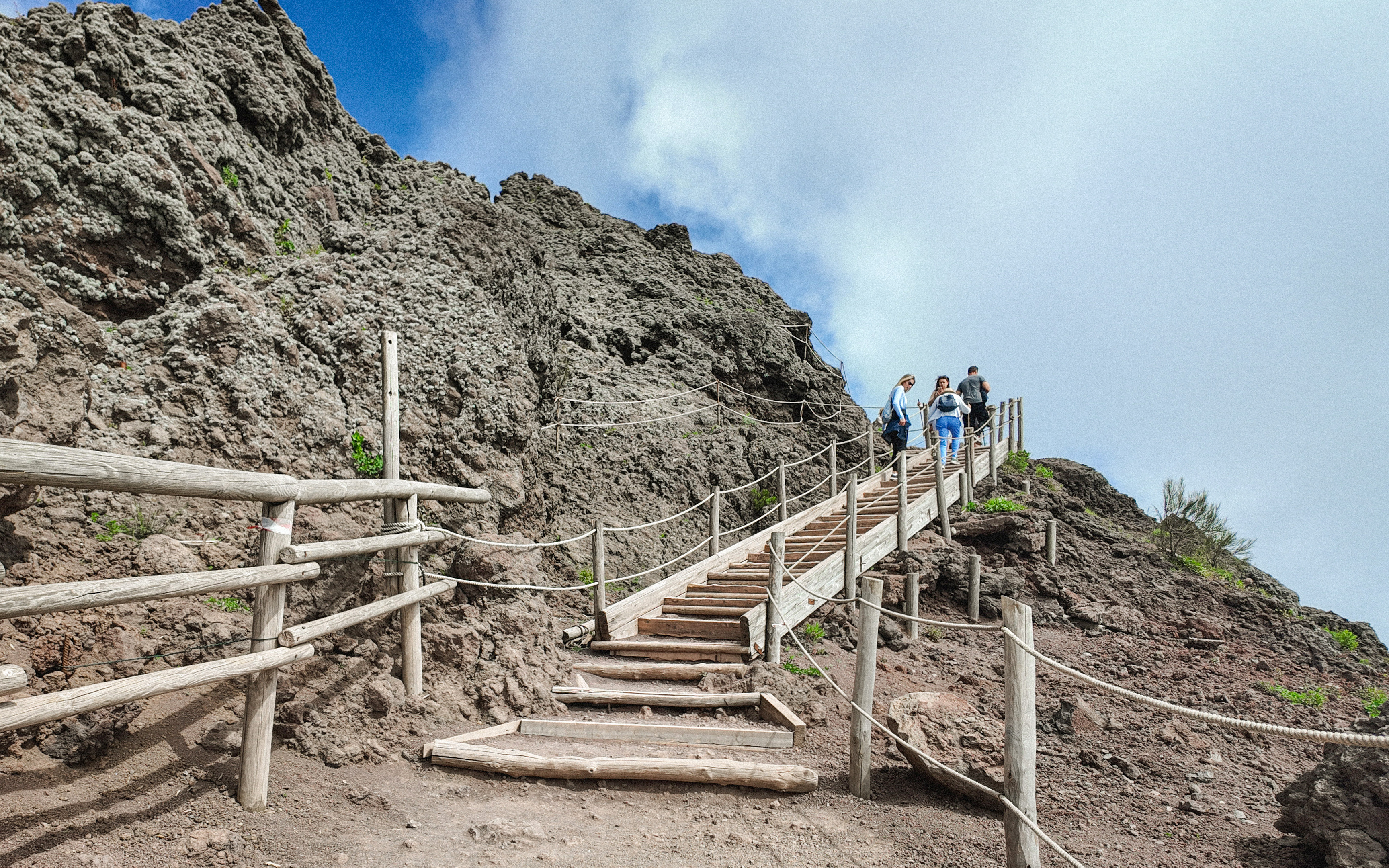 Visitors hiking up wooden steps on Mount Vesuvius, Italy.