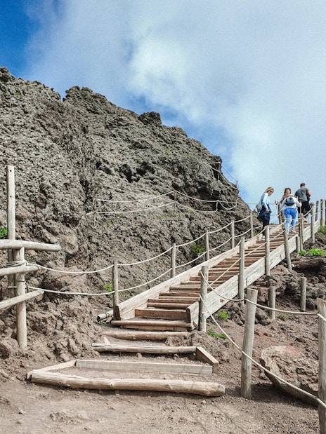 Visitors hiking up wooden steps on Mount Vesuvius, Italy.