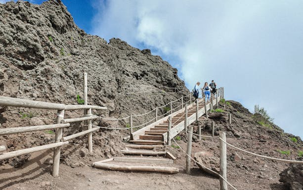 Visitors hiking up wooden steps on Mount Vesuvius, Italy.