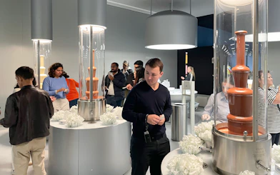 Visitors exploring chocolate fountains at Lindt Home of Chocolate Museum in Zurich.