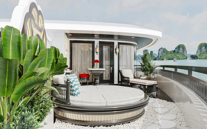 Luxury cruise deck with seating area overlooking Lan Ha Bay limestone karsts.
