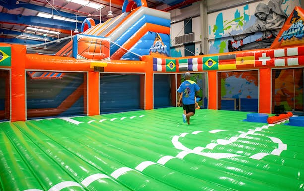 Indoor inflatable park with colorful slides and obstacle course at Air Maniax Adventure.
