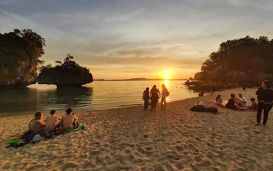Sunset view at Hong Islands beach with people relaxing, Krabi longtail boat tour.