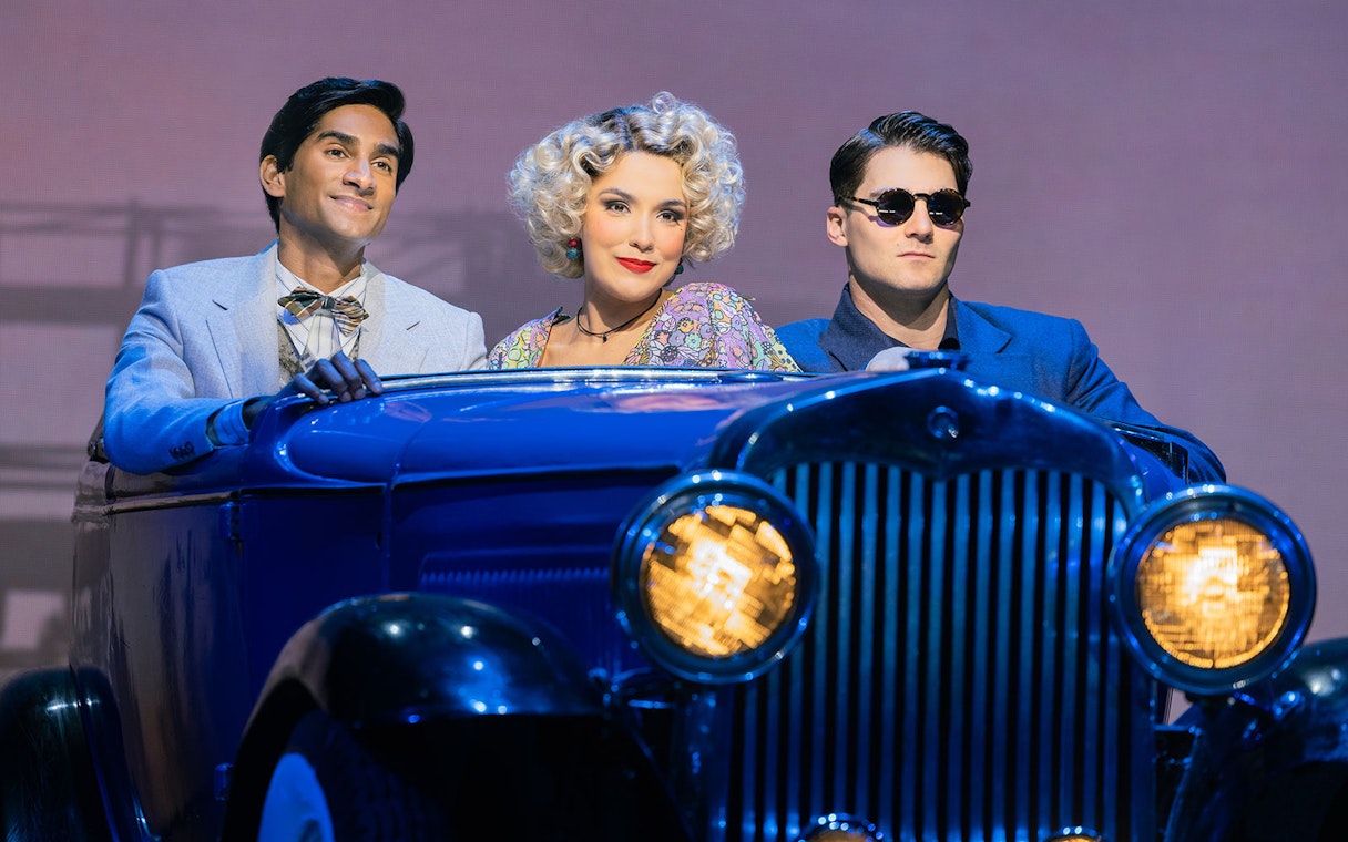 Three people in vintage attire sitting in a classic car, reminiscent of The Great Gatsby.
