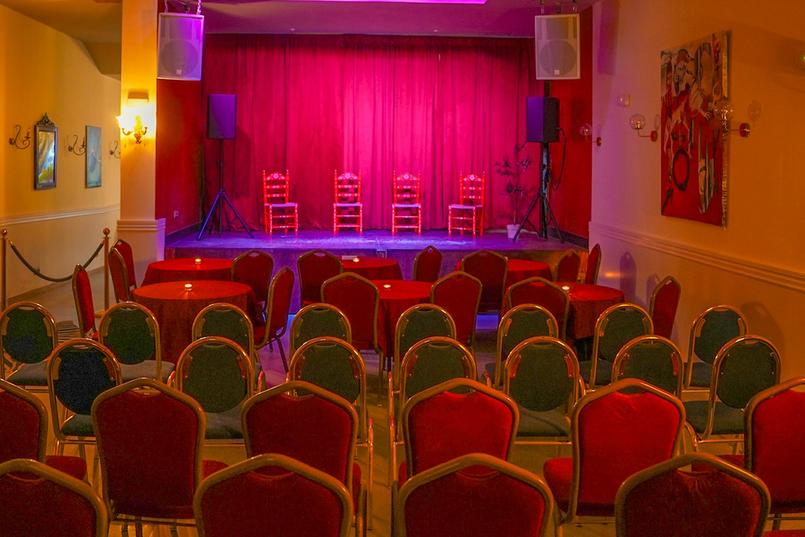 Flamenco Laietana stage with red chairs and tables in a dimly lit venue.