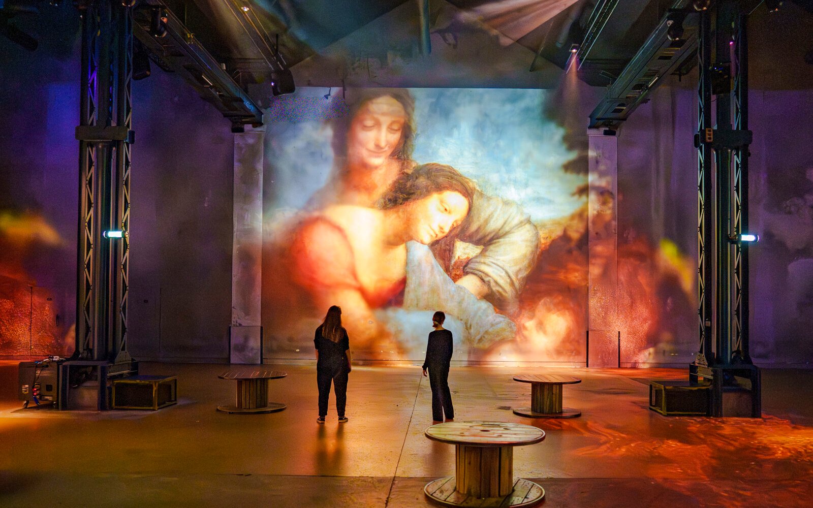 Visitors viewing Renaissance art projection at Atelier des Lumières, Paris, France.