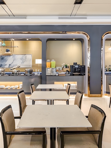 Dining area at Miracle Lounge, Bangkok Airport, Thailand with buffet and seating.