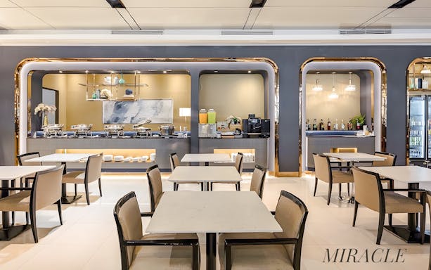 Dining area at Miracle Lounge, Bangkok Airport, Thailand with buffet and seating.