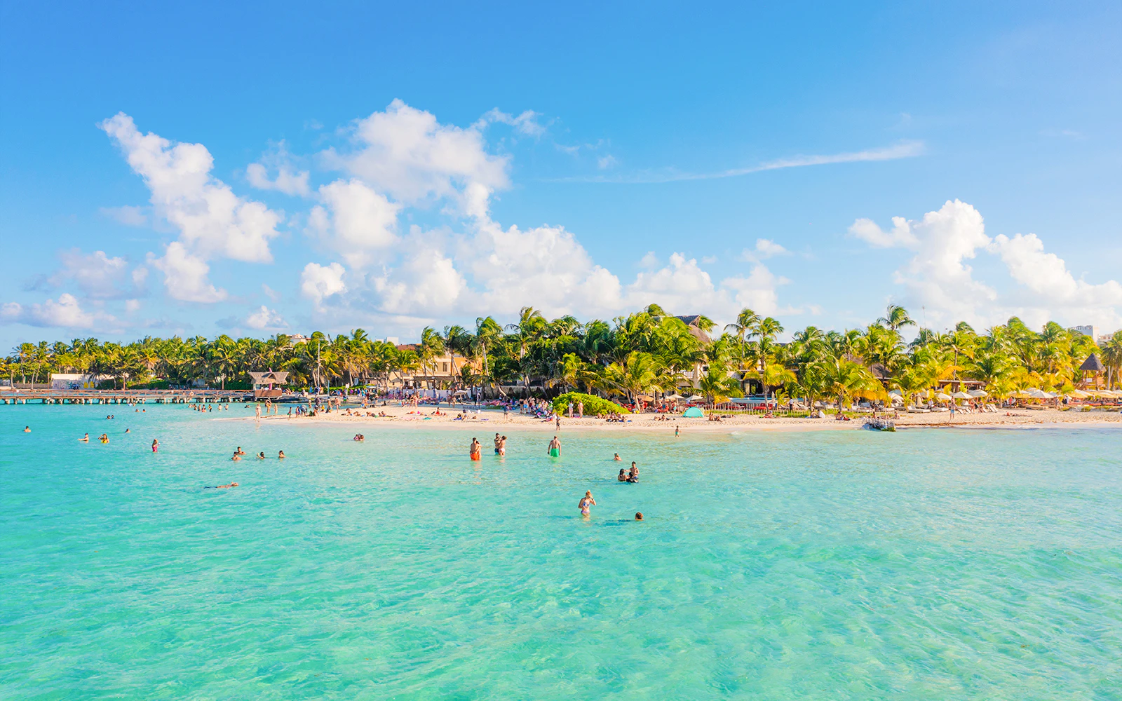 People enjoying the clear waters and sandy beach of Playa Norte, Isla Mujeres.