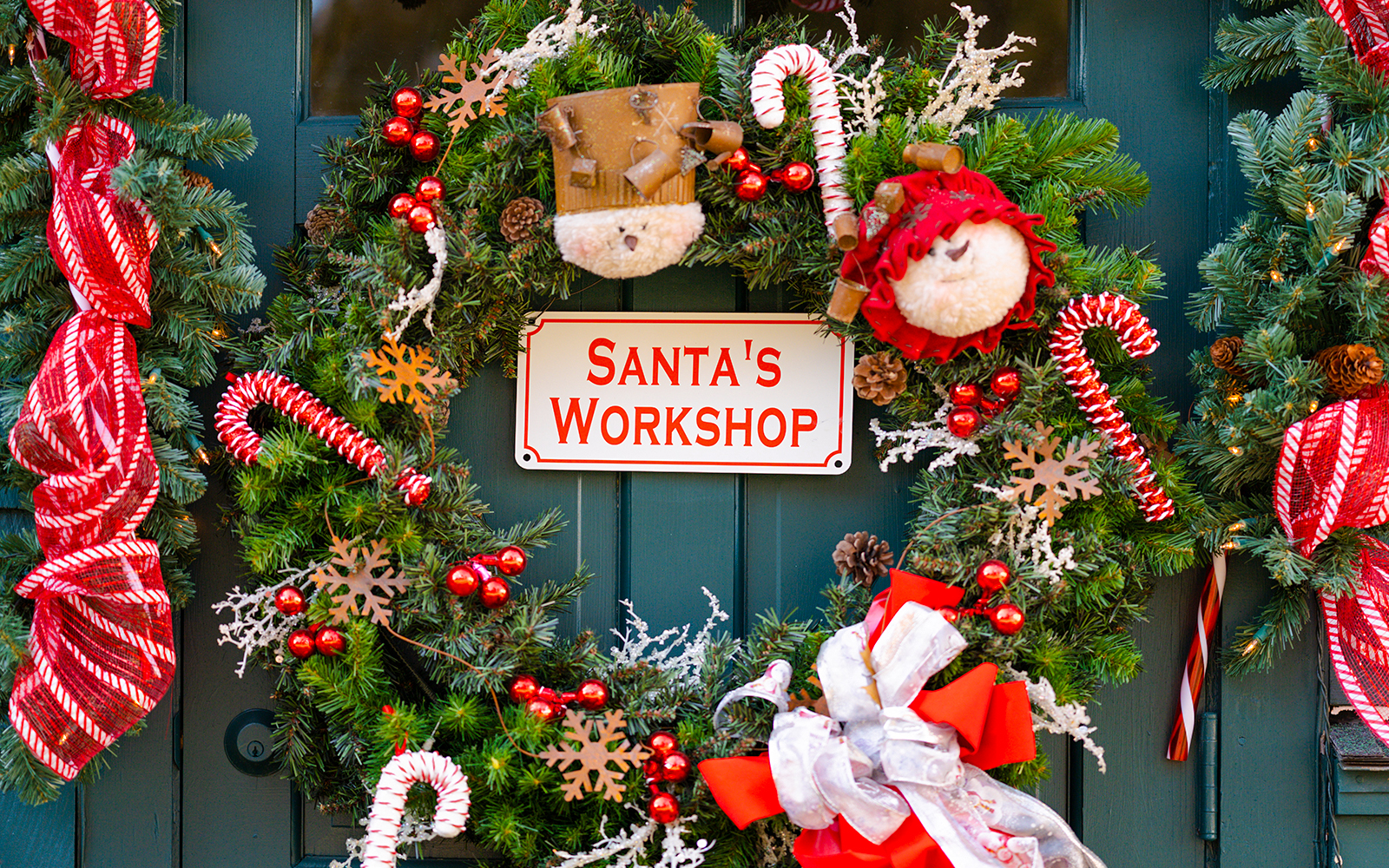 Santa's Workshop sign surrounded by festive wreath with candy canes and ornaments.