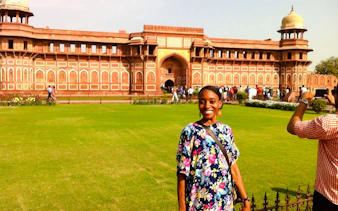 Visitor at Agra Fort with red sandstone architecture, part of Taj Mahal Express Entry Tour.