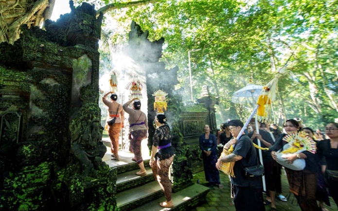 Balinese ceremony at Sacred Monkey Forest Ubud with traditional offerings and attire.