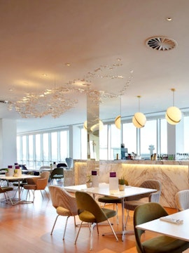 Plaza Premium Lounge seating area with tables and chairs, London Gatwick Airport North Terminal.