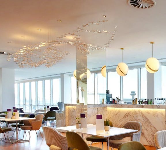 Plaza Premium Lounge seating area with tables and chairs, London Gatwick Airport North Terminal.