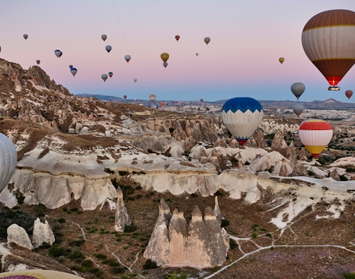 Hot air balloons over Rose Valley, Cappadocia, Turkey, showcasing unique rock formations.