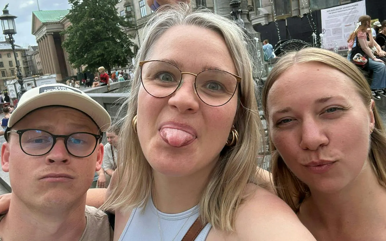 Selfie of three people in front of a historic building in Copenhagen during a city exploration game.