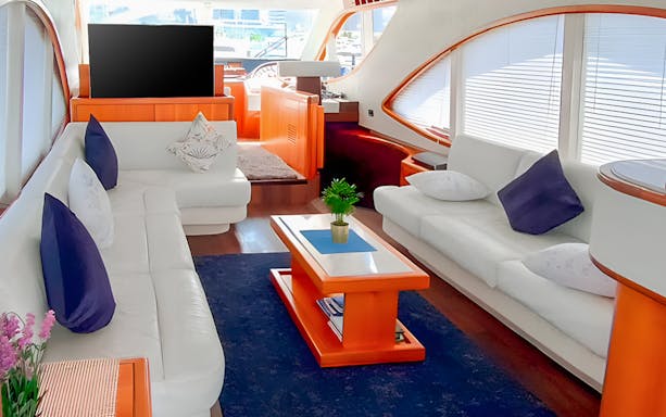 Luxury yacht interior with white sofas and modern decor, Dubai Sunset Yacht Experience.