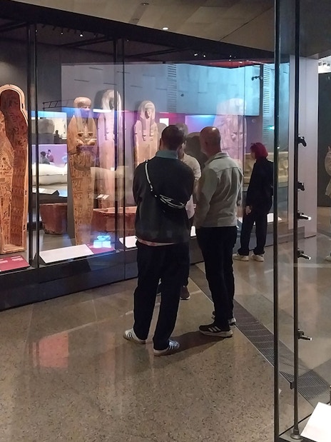 Visitors viewing ancient Egyptian sarcophagi at the Grand Egyptian Museum.