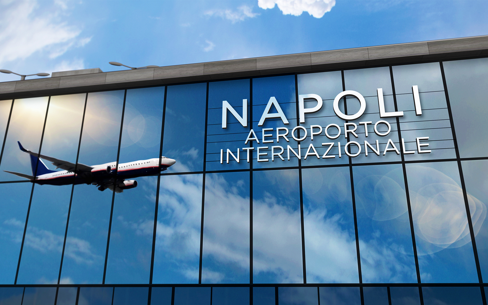 Naples Airport terminal with travelers and parked airplanes in the background.